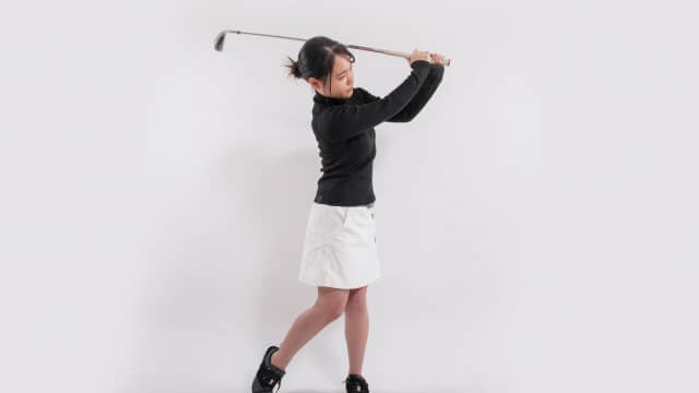 ゴルフ　スイングをする女性